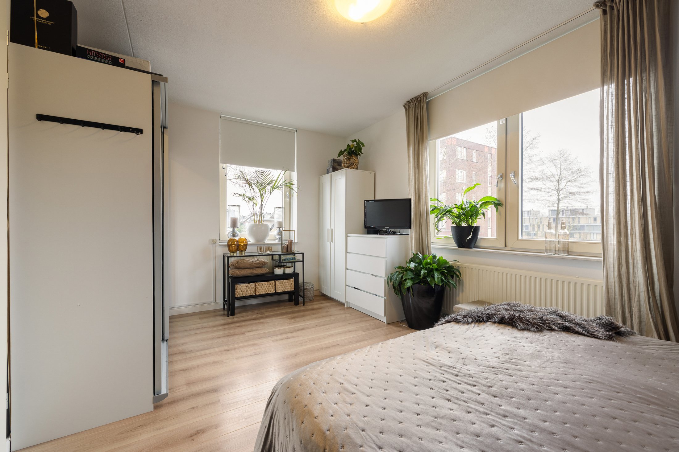 Lichte slaapkamer met kastwand en raam